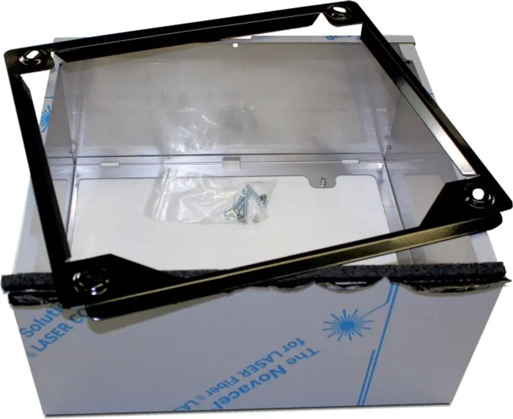 Edelstahlrahmen von Wolf, der auf einem Karton liegt, mit transparentem Innenteil und kleinen Schrauben in einer plastischen Tüte. An einer Seite ist schwarzer Schaumstoff zu sehen.